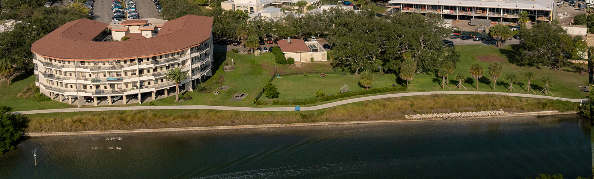 View from water looking at a shoreline as boat and paddleboarders go by