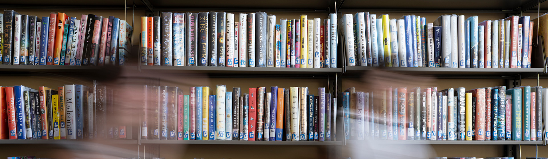 Timelapse of students walking past a library bookshelf